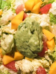 Green salad with grapefruit and mango topped with avocado dressing