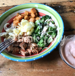 All sorts of flavors and textures in this bowl filled with season tofu, caramelized onions, roasted sweet potato and broccoli and topped with pineapple