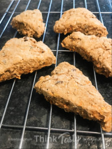 Homemade scone filled with carrots, raisins, and pecans topped with cream cheese frosting