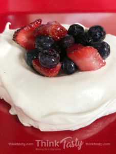 individual pavlova topped with macerated berries