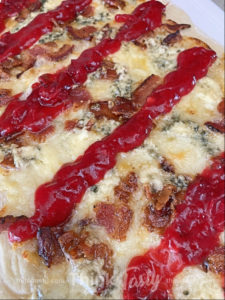 flatbread topped with bacon, blue cheese, and cranberry drizzle